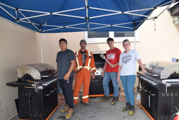 Brock Yazbeck (summer student), Martin Gale (CF Employee), Jeremy MacMillan (summer student), and Keeley McCarter (summer student) from CF Industries in Courtright gather for their final United Way barbeque fundraiser of the summer.