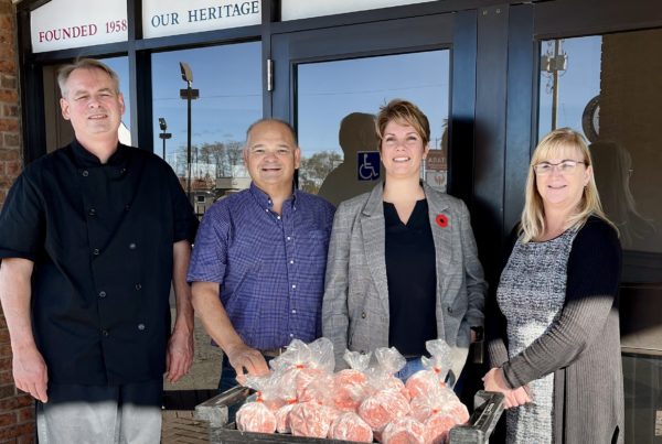 Brian Dunn, Executive Chef at The Dante Club, Dave Brown, United Way, Make Campbell, Ontario Park, and Cathy Thompson, Libro Credit Union and sponsor of the 2022 Frozen Meals Take out Event stand with 90 pounds of donated local ground pork