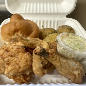 Three piece chicken dinner with roasted potatoes, bun, and coleslaw