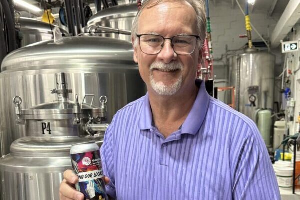 Sarnia Lampton future fund foundation, President, Al McChesney poses with several cans of United Way branded beer at Black Gold Brewery